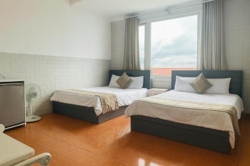 a room with two beds and a tv in it at LE VU HOTEl in Da Lat