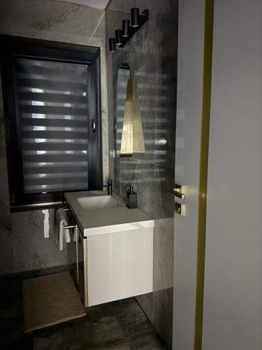 a bathroom with a white sink and a mirror at Galactic&Ludmila Suite SPA in Braşov