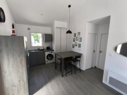 cocina y comedor con mesa y fogones en Maison vendéene bord de mer - env 1 km plage-, en Saint-Vincent-sur-Jard