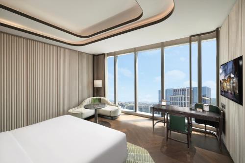 a hotel room with a bed and a desk at MGM Qingdao in Qingdao