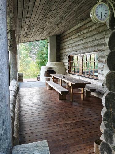 a wooden porch with benches and a clock on the wall at Villa Lilja in Muurame