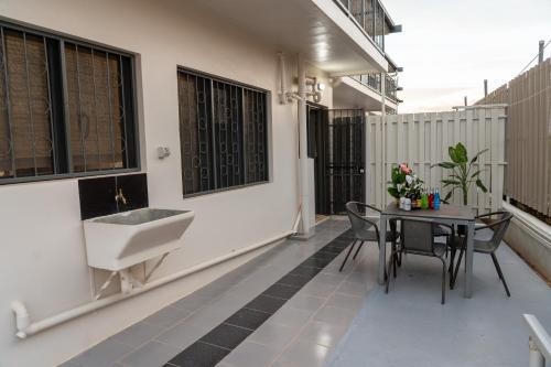 a balcony with a sink and a table with chairs at Airport Ace Villas in Nadi
