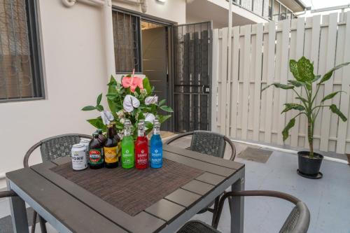 a picnic table with bottles and flowers on it at Airport Ace Villas in Nadi