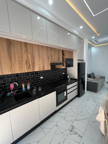 a kitchen with white cabinets and black counter tops at DjerbaArkouMidoun in Arkou