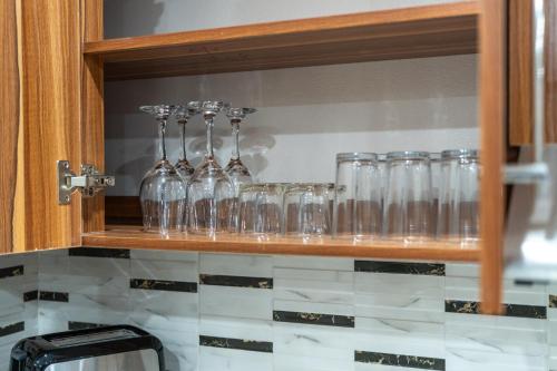 a row of glasses on a shelf in a kitchen at Airport Ace Villas in Nadi