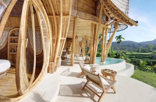 an outdoor patio with a large wooden building at Eden Villa by SARAYA Bali in Silebeng