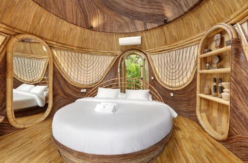 a bedroom with a bed in a room with wooden walls at Eden Villa by SARAYA Bali in Silebeng