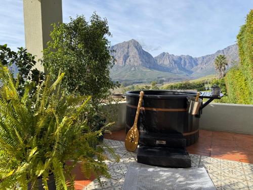 a barrel sitting on a patio with a view of mountains at Esperon in Stellenbosch