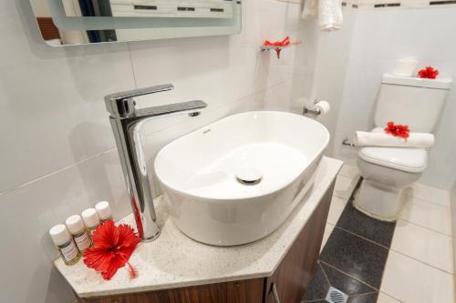 a white bathroom with a sink and a toilet at Airport Ace Villas in Nadi