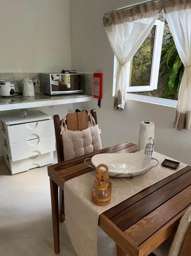 a dining room with a table and a kitchen at SOUTH HILL VILLA in Mahe
