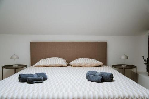 a large bed with two blue pillows on it at Room Urban Chic in Reims