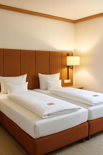 two large beds in a hotel room with at Parkhotel an der Therme in Bad Krozingen