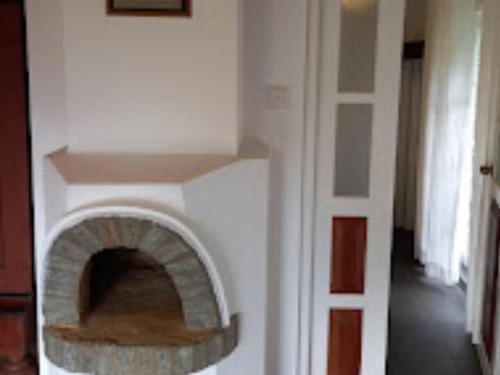 a living room with a brick fire place in a wall at Forest Edge Hotel in Ginigathena