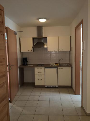 a kitchen with white cabinets and a tile floor at Boardinghouse Casita Amann in Friedrichshafen