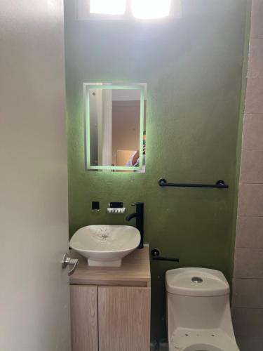 a bathroom with a sink and a toilet and a mirror at RC Studio loft san Jerónimo in Miravalle