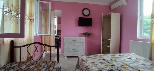 a bedroom with pink walls and a bed and a mirror at Apartment on Kobuleti beach. in K'obulet'i