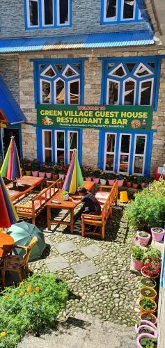 a building with tables and umbrellas in front of it at Green Village guest house & hotel in Phakding