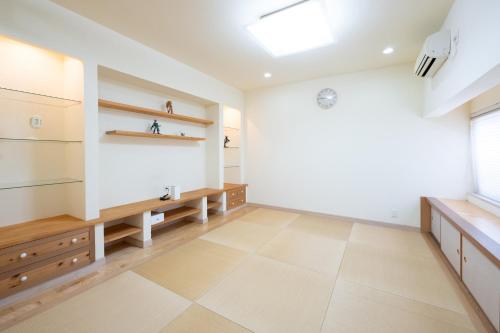 a kitchen with white walls and wooden cabinets and a window at KANNONJI syu - 観音寺 集 - in Kanonji