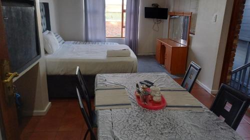 a hotel room with two tables and a bed at Neat Haven Self Catering in Grahamstown