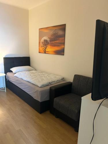 a bedroom with a bed and a couch and a television at Wohnung in Troisdorf T04 in Troisdorf