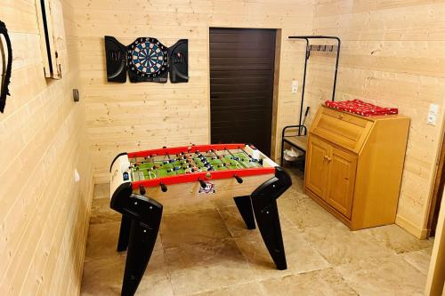 una habitación con una mesa y un tablero de dardos en la pared en Chalet le Petit Coeur, en Xonrupt-Longemer