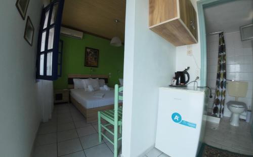 a small room with a bed and a refrigerator at Studios Ntina in Alyki