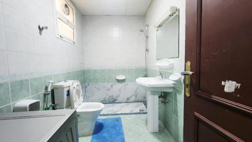 a bathroom with a toilet and a sink at Family Room in Abu Dhabi