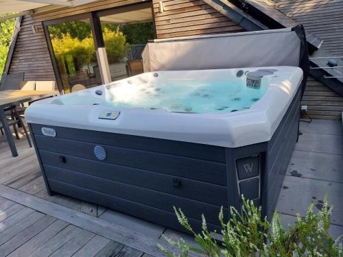 a jacuzzi tub sitting on a deck at Gite Spa les Estinnes in Estinnes-au-Mont