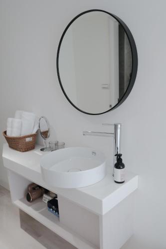 a bathroom with a white sink and a mirror at 芭驛 8hundredmillion I 安平運河景觀住宿 in Anping