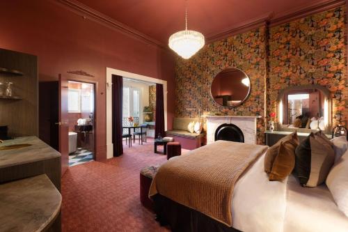 a bedroom with a large bed and a fireplace at Medusa Hotel Sydney in Sydney