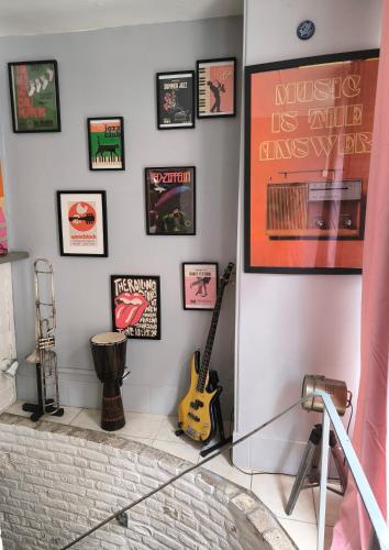 a room with musical instruments on a wall at LE MADISON, Gîte Atypique - NETFLIX in Dieppe