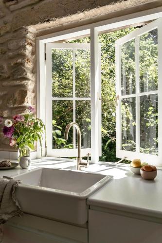 a kitchen with a sink and a window at Stone Gate Cottage in Aldgate
