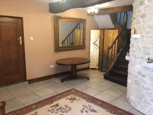 a room with a table and a mirror on the wall at Moulin la vergne in Champagne-et-Fontaine