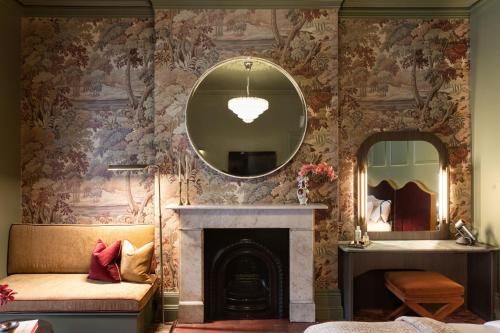 a living room with a fireplace and a mirror at Medusa Hotel Sydney in Sydney