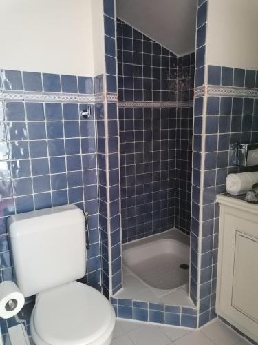 a blue tiled bathroom with a toilet and a tub at Hôtel l'Arena in Fréjus