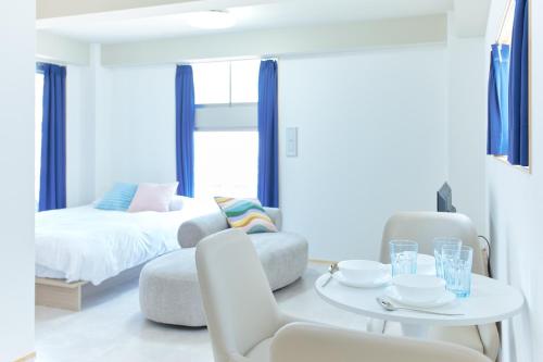 a white room with a bed and a table and chairs at Liberty Place Nakano by Tranova in Tokyo