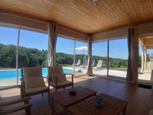 ein Wohnzimmer mit Poolblick in der Unterkunft Domaine de la Marandine in Le Vigan