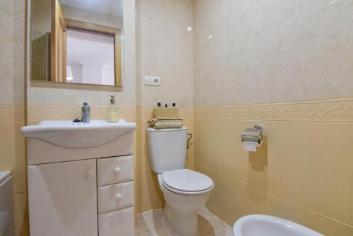 a bathroom with a toilet and a sink and a mirror at Magic Sunset View in El Borseral