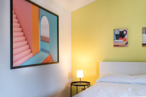 ウーディネにあるLe Mandarine Apartments - Double Roomのベッドと壁に絵が飾られた寝室