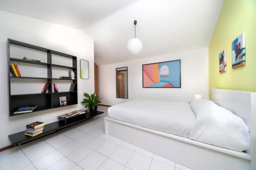 ウーディネにあるLe Mandarine Apartments - Double Roomのベッドルーム(白いベッド1台、棚付)
