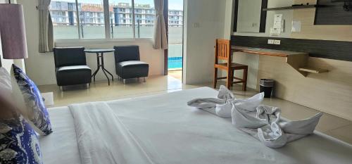 a bedroom with a bed with pillows on it at AM Surin Place - SHA Extra Plus in Surin Beach
