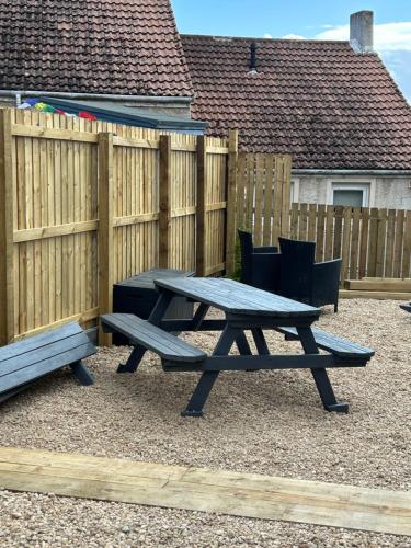 a picnic table in front of a wooden fence at The Terrace in Saint Monance
