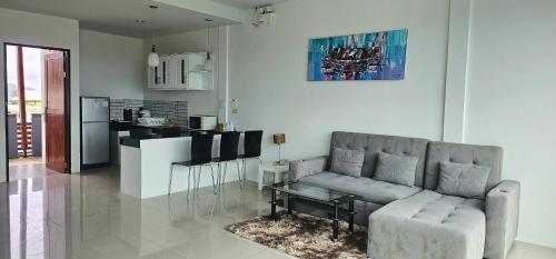a living room with a couch and a kitchen at AM Surin Place - SHA Extra Plus in Surin Beach