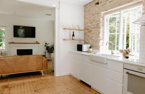 a kitchen with a sink and a fireplace at Stone Gate Cottage in Aldgate
