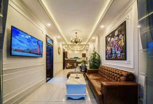 a living room with a couch and a tv on the wall at Tiên Hoa Sơn Villa in Da Lat