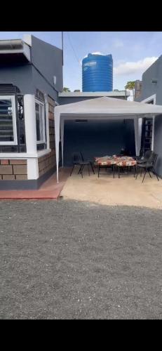 a patio with chairs and a table in front of a building at Cnc bnb Kimana- 3bedroom in Gatunga