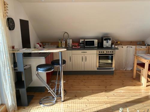 a kitchen with a table and two stools at Apartmán Nejdek in Nejdek