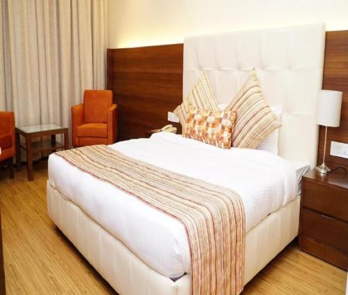 a large white bed in a hotel room at Hotel Hampton International Near Delhi Airport in New Delhi