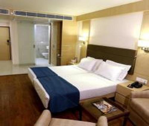 a hotel room with a large bed and a couch at Hotel Hampton International Near Delhi Airport in New Delhi