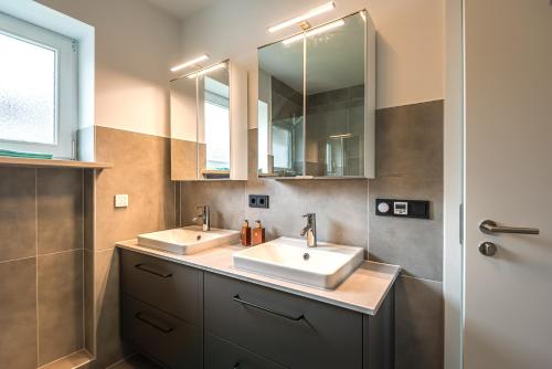 a bathroom with two sinks and a mirror at Im Grasweg - Just 7 Minutes From MUC Airport in Neufahrn bei Freising